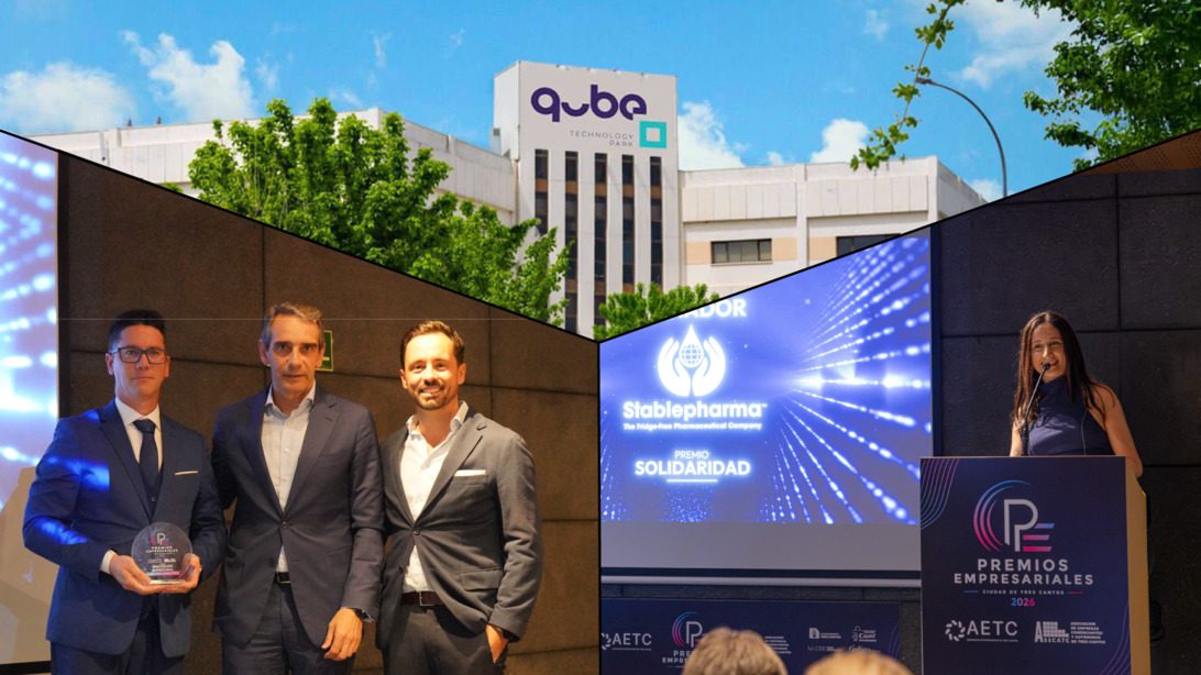 Qube SmartBio Stablepharma - IP - i-Healthcare Three men in suits pose on stage after receiving an award at a tech event, with a presenter at a podium to the right.