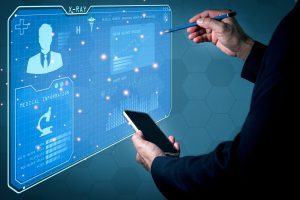 Biociberética - IP - i-Healthcare Doctor or technician interacting with a blue holographic medical dashboard, holding a smartphone and pen.